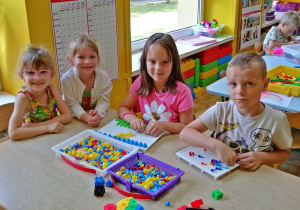Dzieci bawią się układanką przy stoliku